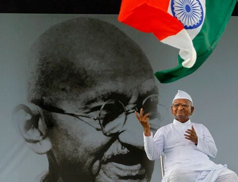 Indiens prominentester Kämpfer gegen Korruption, Anna Hazare, sitzt vor einem Porträt von Mahatma Gandhi in Neu Delhi. (FOTO: AFP)