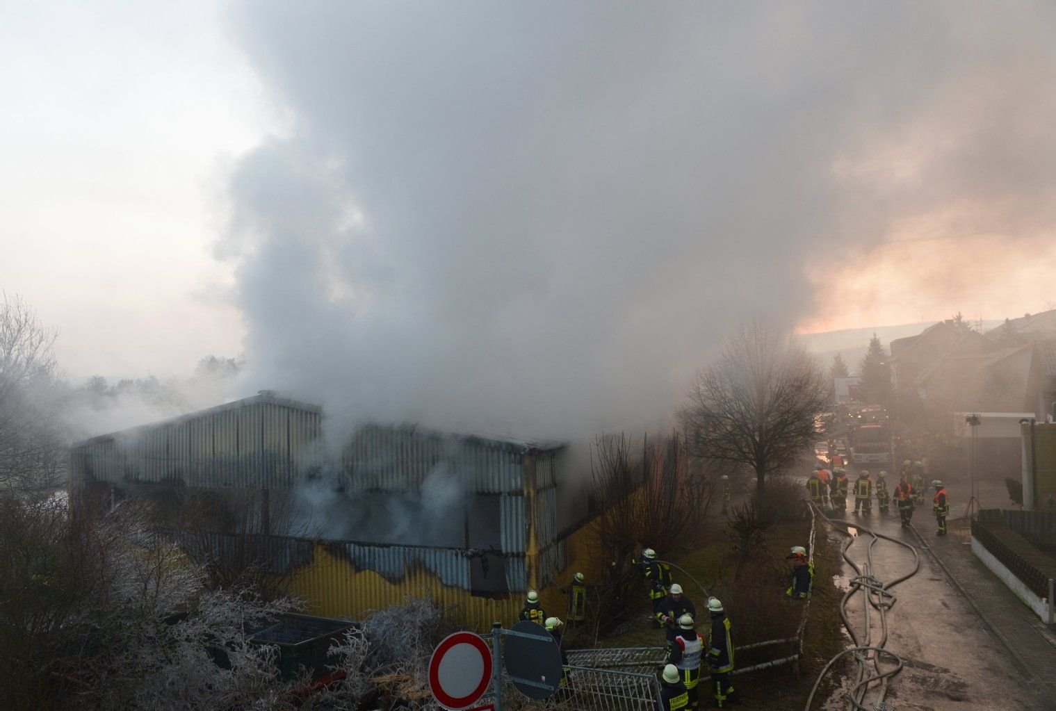 Feuerwehrleute sind am Sonntag an der ausgebrannten Scheune eines Reiterhofs in Taunusstein-Wehen (Rheingau-Taunus-Kreis, Hessen) mit Löscharbeiten beschäftigt. Das Feuer war aus noch ungeklärter Ursache in der Scheune ausgebrochen.
