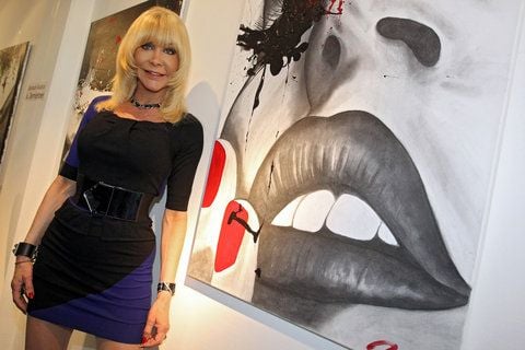 Die Erotik-Produzentin Nora Dvorak, alias Dolly Buster, posiert in ihrer Ausstellung in Fürth (Mittelfranken) vor dem Gemälde «Shooting». (FOTO: DPA)