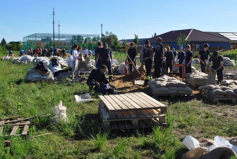Zahlreiche freiwillige Helfer, unter ihnen auch Sekundarschüler, füllen in Elster Sandsäcke. Mit ihnen wird ein Notdamm verstärkt und abgedichtet sowie ein weiteres Vordringen des Wassers in der Dresdener Straße verhindert.