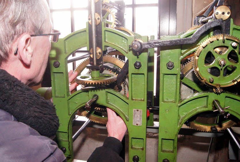 Stadt-Hausmeister Hans-Joachim Lehmann stellt das Jessener Kirchturm-Uhrwerk auf die aktuelle Zeit ein.