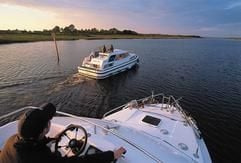 Leinen los im Morgengrauen - bei Sonnenaufgang lässt sich die Landschaft noch einmal ganz anders erleben. Manchmal begleiten Reiher und Höckerschwäne die Fahrt, manchmal haben die Skipper den Fluss ganz für sich. (Foto: Irisches Fremdenverkehrsamt/dpa/gms)