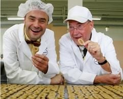 Der Unternehmer Dr. Hartmut Quendt (r.) probiert mit seinem Sohn Matthias Quendt in der Dresdner Dr. Quendt Backwaren GmbH an einem Laufband «Russisch Brot». (Foto: dpa)