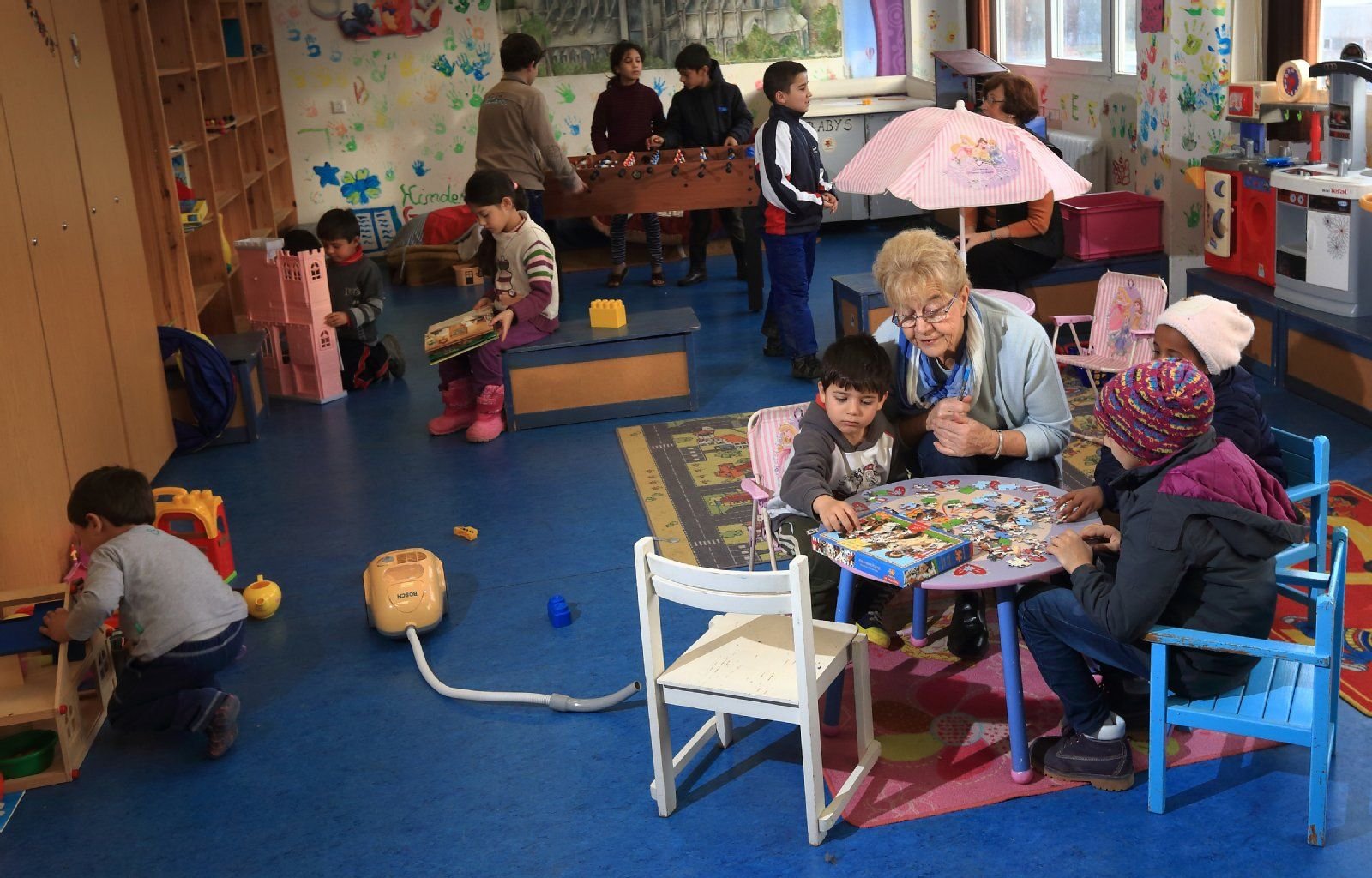 Gisela Eidner (2.v.r.), ehrenamtliche Mitarbeiterin im Kindergarten in der Zentralen Anlaufstelle für Asylbewerber (Zast) in Halberstadt, berteut ausländische Kinder.