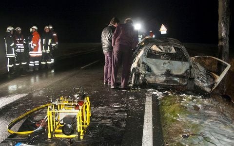 Bestatter stehen nach einem Unfall auf der Landstrasse 475 (L475) im Landkreis Hildesheim neben einem ausgebrannten Pkw. (FOTO: DAPD)