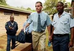 Der tatverdächtige weiße Farmer Mark Scott-Crossley (M.) wird in das Gerichtsgebäude in Phalaborwa in Südafrika geführt. (Foto vom 21.04.2005). Ein Schädel, ein Finger, ein Stück Stoff - das war alles, was von Nelson Chisale übrig blieb: Der 41-jährige Südafrikaner wurde von Löwen zerrissen. (Foto: dpa)