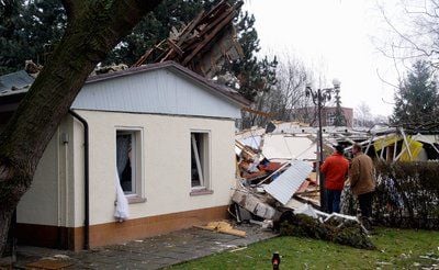 Zwei Passanten betrachten in Schkeuditz ein von einer Explosion zerstörtes Einfamilienhaus. (FOTO: DDP)