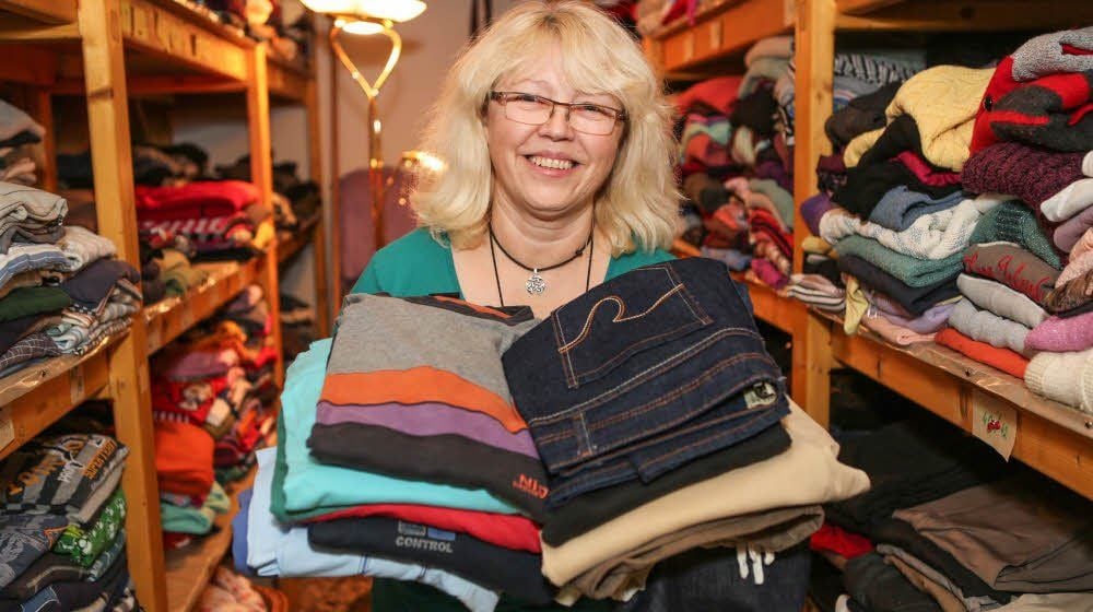 Die Regale der Kösa-Kleiderkammer in Hohenmölsen sind mit warmen Sachen schon gut gefüllt, wie deren Leiterin Dagmar Hess zeigt.