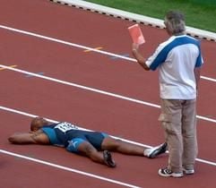 Der US-amerikanische Sprinter Jon Drummond liegt auf der Laufbahn und bekommt von einem Kampfrichter die Rote Karte gezeigt. Sein Protest gegen seine Disqualifikation nach seinem Fehlstart sorgte für einen Skandal bei der WM. Nach der neuen Fehlstart-Regel wird ein Sprinter disqualifiziert, wenn er den zweiten Fahlstart in seinem Rennen auslöst. (Foto: dpa)