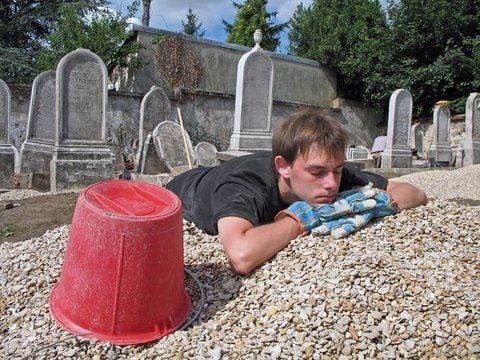 In den Sommerferien sind Arbeiten in Workcamps sehr beliebt. Der junge Mann hier braucht nach der Arbeit auf einem jüdischen Friedhof eine Pause. (FOTO: DPA)