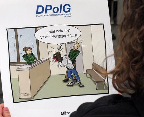 Die März-Karikatur des Kalenders zeigt einen festgenommenen Afrikaner mit dicken roten Lippen, der sich gegen den Griff eines Polizeibeamten wehrt. Er schreit in gebrochenem Deutsch: «Was heiß' hie' Ve'dunklungsgefah' ....?!» (FOTO: DPA)