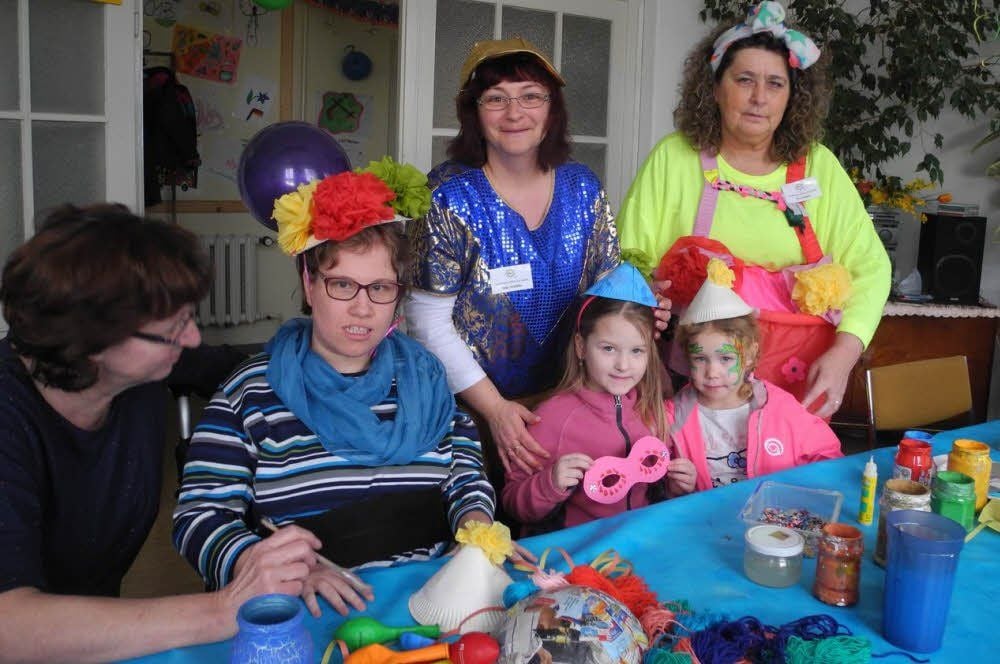 Christa Leesemann und Sandra Richter (l.) sowie die Kinder Hanna und Josephine werden von Silke Schöller und Eva Reinel vom „Wir“-Verein beim Anfertigen von Masken und Hütchen beraten.