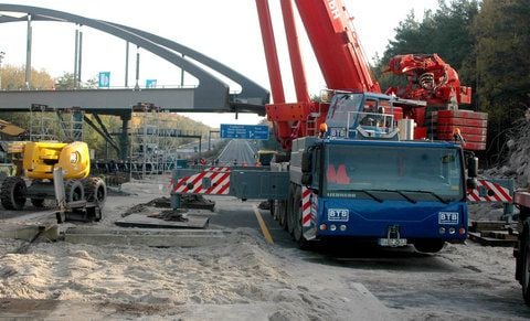 Die 67 Meter lange und 420 Tonnen schwere neue Eisenbahnbrücke wird am Samstag nahe dem brandenburgischen Ferch langsam über die Autobahn A10 am südlichen Berliner Ring geschoben. (FOTO: DPA)