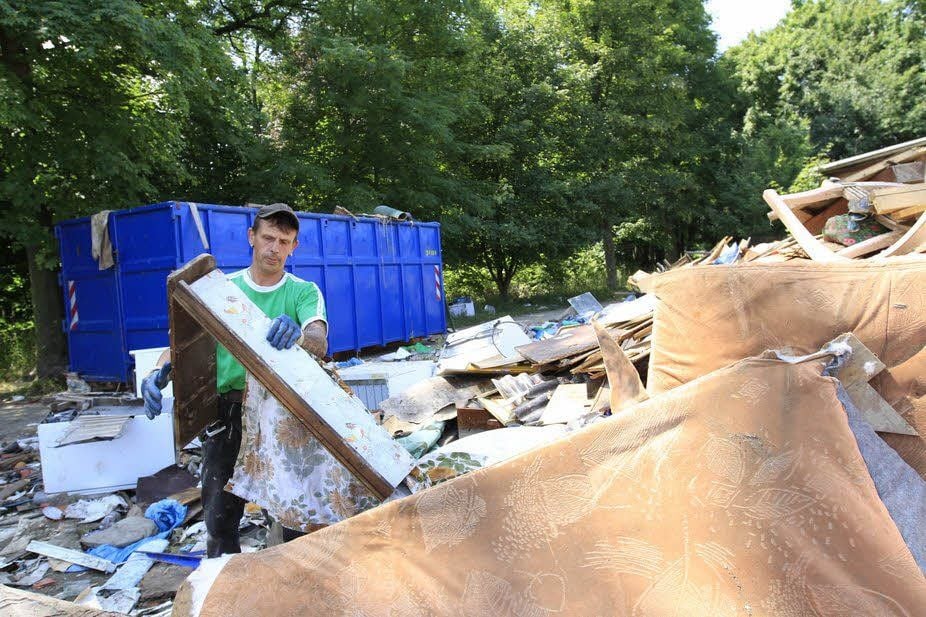 Enrico Dey belädt Container an der Gartenanlage Untere Promenade in Zeitz. Was hier liegt, hat das Hochwasser in Gartenlauben zerstört.