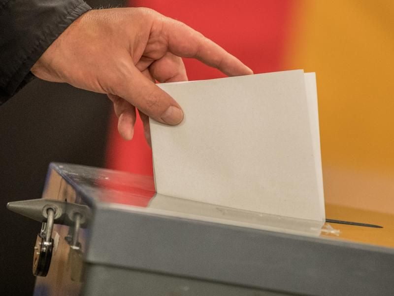Ein Wähler wirft seinen Stimmzettel in die Wahlurne. Foto: Michael Kappeler/Archiv