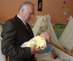 Sachsen-Anhalts Ministerpräsident Wolfgang Böhmer (CDU) hat in Dessau bei einem Besuch der neugeborenen Drillinge der Familie Laube einen der Säuglinge auf dem Arm. (Foto: dpa)