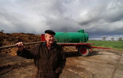 Der pensionierte Landwirt Ulrich Toppel an einem Acker bei Pritzwalk (Prignitz) in Brandenburg vor einem Tankwagen mit einer Mistgabel. Toppel war Opfer der Zwangskollektivierung der Landwirtschft in der DDR. (FOTO: DDP)
