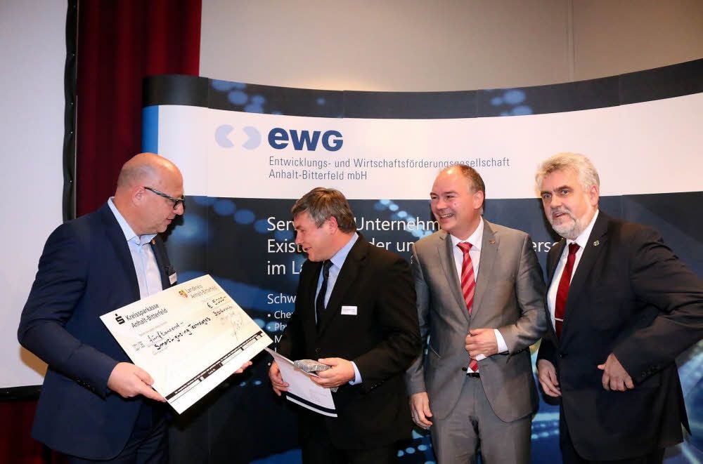 Vize-Landrat Bernhard Böddeker (links) überreicht Eduard Siemens, Professor an der Hochschule Anhalt, den Preis von Kreis und Sparkasse. Hochschulpräsident Jörg Bagdahn freut sich mit Landes-Wissenschaftsminister Armin Willingmann (rechts). Beide sind die ersten Gratulanten.