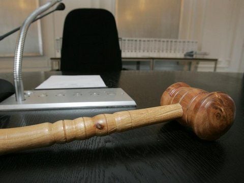 Ein Richterhammer liegt auf einem Tisch.