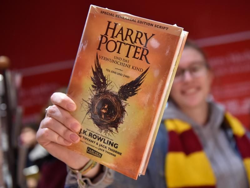 Eine Frau zeigt ihren neuen Harry-Potter-Roman. Foto: Klaus-Dietmar Gabbert/Archiv