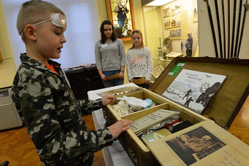 Iven-Thore, Kimberly und Anna Sophia erklären den Inhalt des Museumskoffers, der für Grundschulen gedacht ist.