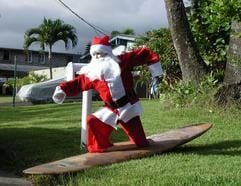 Eine Weihnachtsmannfigur steht am 11.12.2005 in Kailua etwa 40 Kilometer nordöstlich von Honolulu (Hawaii) in einem Vorgarten auf einem Surfbrett. (Foto: dpa)