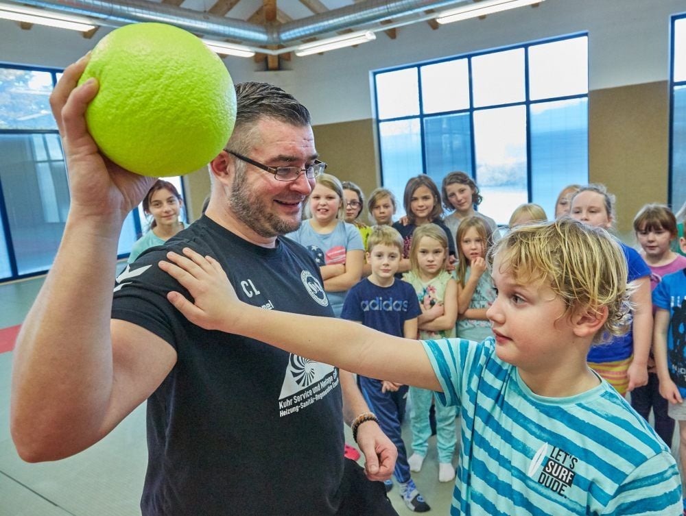 Der siebenjährige Paul lässt sich von Claus Luther die ersten Handballtricks beibringen.