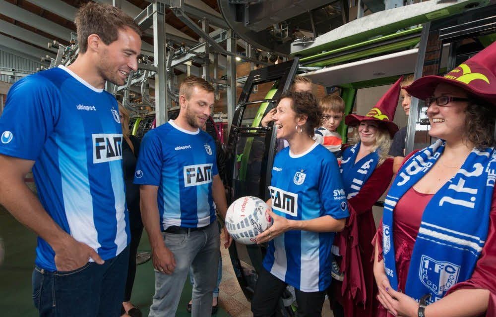 Pamela Groll (Mitte) bekam von den Spielern Steffen Puttkammer (l.) und Lars Fuchs (2.v.l.) neben einem Trikot auch einen Ball mit allen Unterschriften der Spieler und Trainer geschenkt.