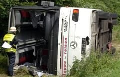 Ein Feuerwehrmann untersucht am Montag (4. Juli 2005) einen umgekippten Bus am Autobahnkreuz Meckenheim. Bei dem schweren Busunglück bei Bonn sind etwa 30 Menschen verletzt worden. (Foto: dpa)
