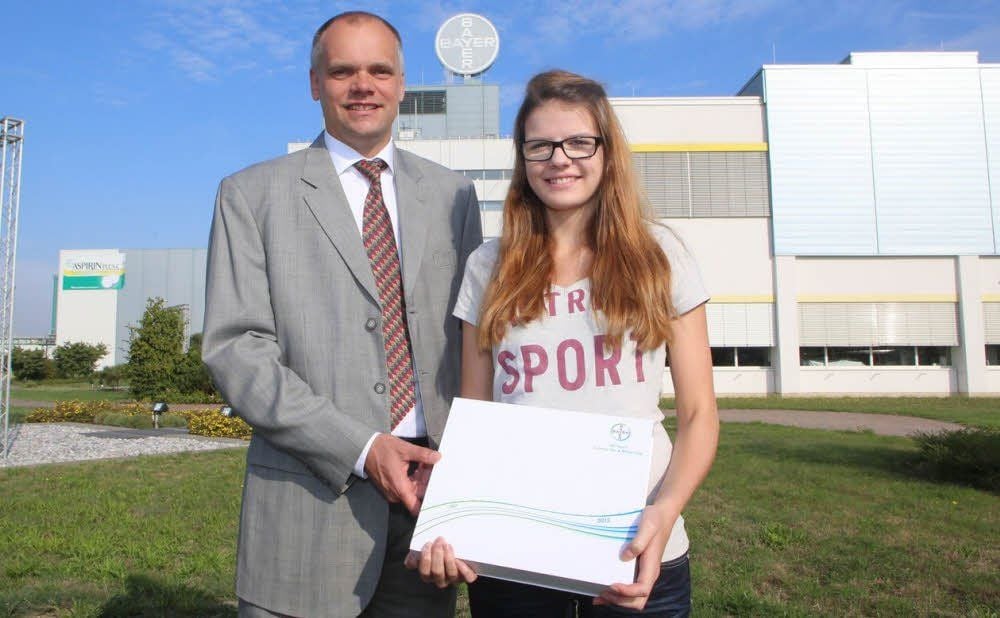 Kelly Gradehand - hier mit Bayer-Bitterfeld-Chef Christian Schleicher - ist die 600. Auszubildende.