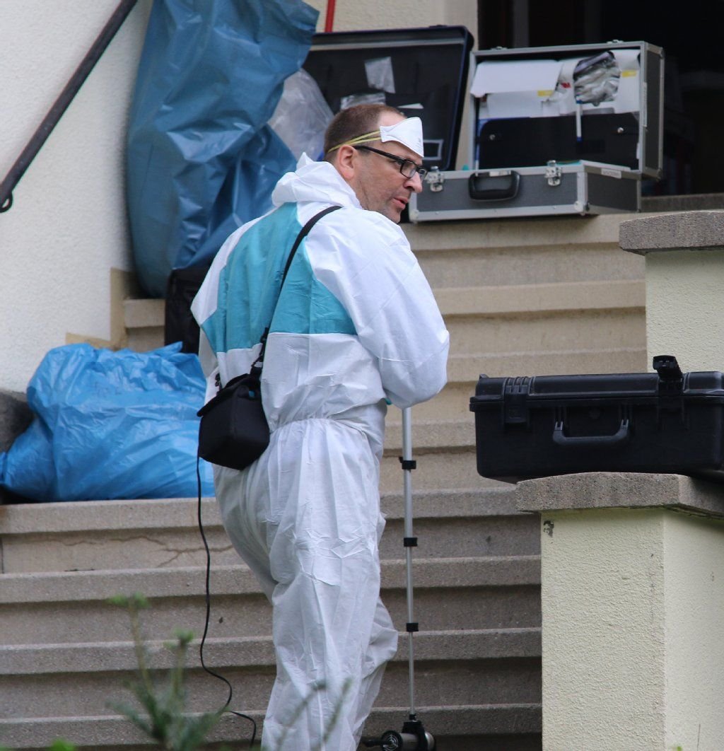 Ein Polizeibeamter der Spurensicherung steht im Eingang des Hauses in Wernigerode (Sachsen-Anhalt), in dem sich am 29.09.2015 ein Familiendrama mit drei Toten ereignet haben soll.