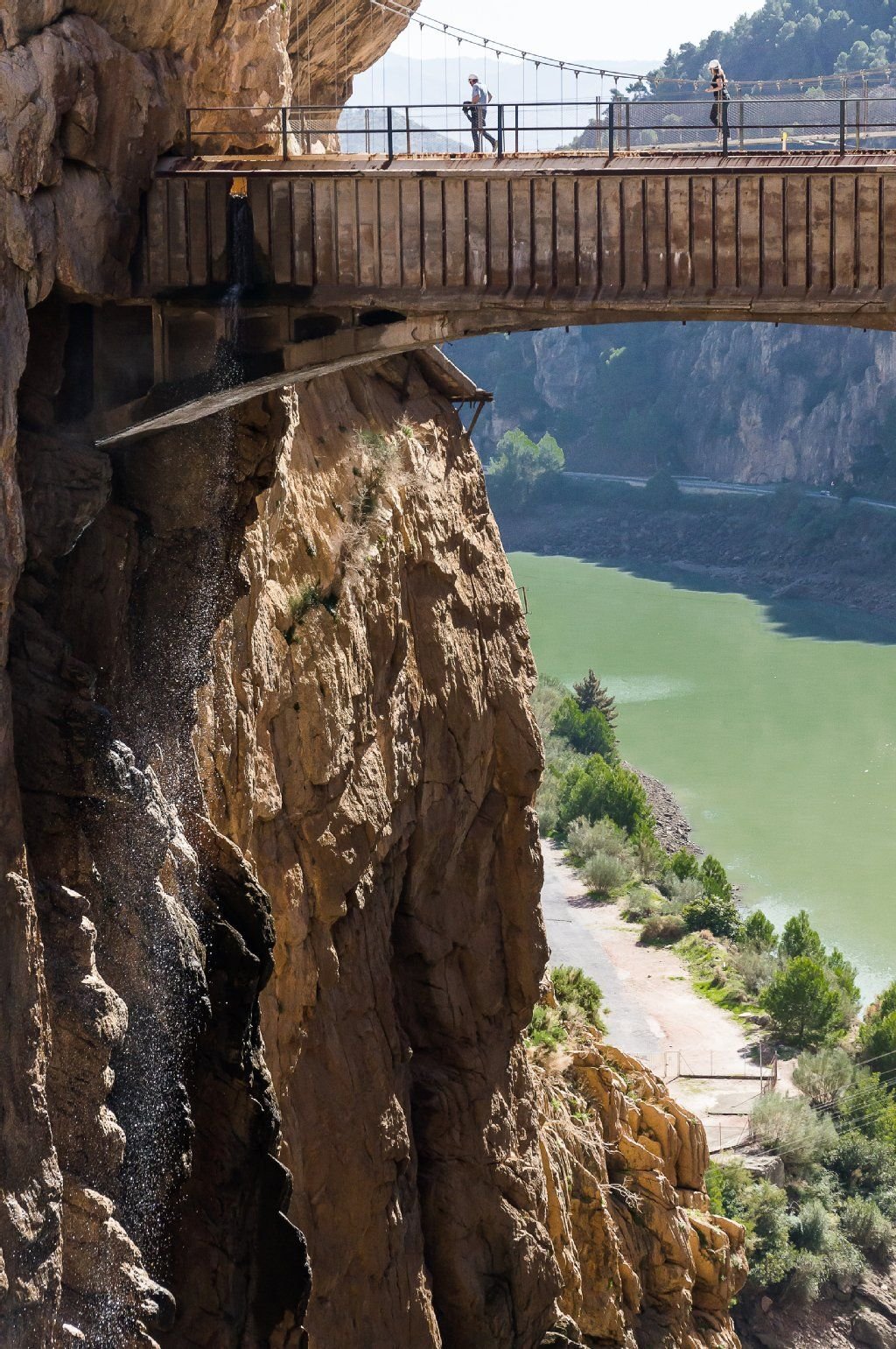 Höhepunkt einer Begehung des Caminito del Rey ist die Hängeblücke am Ausgang der Schlucht. Links fällt ein Wasserfall in die Schlucht hinab, im Hintergrund sieht man die Talsperre.