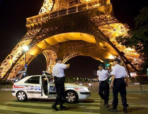 Französische Polizisten stehen am Dienstagabend vor dem Eiffelturm in Paris. (FOTO: DPA)
