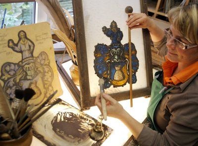 Glasmalerin Martina Gärlich arbeitet in der Werkstatt der kleinen Firma Domglas Naumburg an einem alten Familienwappen eines Sattlermeisters (FOTO: DPA)