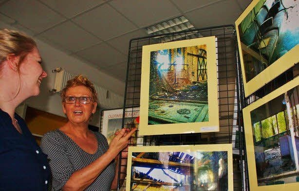 Anke Ernst (links) sieht sich in der „Bücherfee“ die Handyfotos von Karin Paul an.