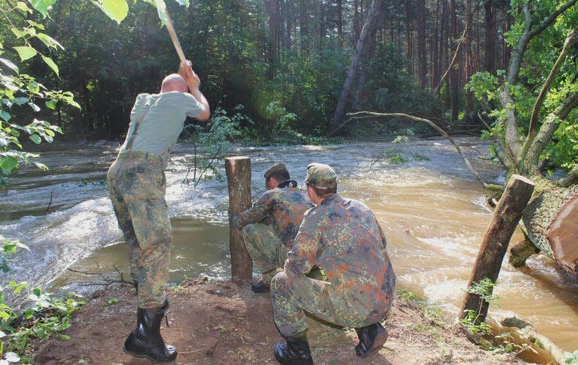 Auf Dessauer Seite wurde ein Deich gebaut, an der Überströmungsstelle arbeiten Soldaten.