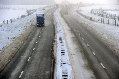 Ein LKW ist auf einer verschneiten Autobahn unterwegs. (FOTO: DPA)