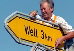 Streckenwärter Karl-Heinz Lasch arbeitet am Dienstag (07.09.2004) an einer Straßenkreuzung in Garding (Kreis Nordfriesland) an dem Straßenschild Welt. Viele Dörfer oder Ortsteile in Schleswig-Holstein tragen Namen, die das Urlauberherz höher schlagen lassen. Das nördlichste Bundesland ist eine wahre Fundgrube für klangvolle und skurile Ortsnamen. (Foto: dpa)