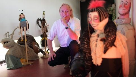 Michael Kempchen, Intendant des Puppentheaters Magdeburg, hockt am Dienstag in Magdeburg zwischen Figuren. Dort wurde zuvor während einer Pressekonferenz über die bevorstehende Spielzeit informiert. (FOTO: DPA)