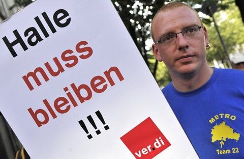 Ein Beschäftigter des Großhandelsunternehmens Metro protestiert am Dienstag in Berlin mit einem Plakat mit der Aufschrift «Halle muss bleiben!!!» gegen die geplante Schließung von Metro-Märkten. (FOTO: DDP)
