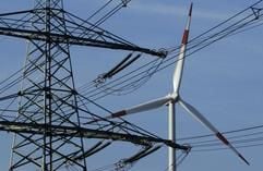 Eine Windenergieanlage dreht sich hinter einer Hochspannungsleitung des Umspannwerkes Wolmirstedt. Für die Stromversorgung von Sachsen-Anhalt ist es einer der wichtigsten Knotenpunkte. (Foto: dpa)