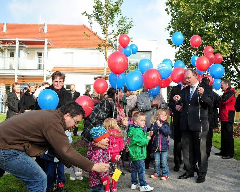 Der Betriebskindergarten ist eröffnet. Zur Feier des Tages steigen Luftballons in den Himmel über Piesteritz. Der Ministerpräsident (rechts) macht mit.
