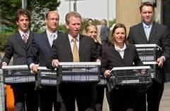 Acht Faltkörbe voll mit Klageschriften gegen die Deutsche Telekom tragen die Rechtsanwälte Peter Kühn (2. v.l.), Ralf Plück (3. v.l.) und Diane Hilty (5. v.l.) am Montag (12.05.2003) gemeinsam mit Mitarbeitern ihrer Kanzlei in das Landgericht von Frankfurt am Main. (Foto: dpa)