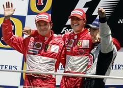 Der deutsche Formel 1-Pilot Michael Schumacher (Ferrari) jubelt am Sonntag (20.06.2004) nach seinem Sieg beim Großen Preis der USA in Indianapolis mit seinem Teamkollegen Rubens Barrichello (Brasilien, l) und dem Japaner Takuma Sato (BAR, r). (Foto: dpa)