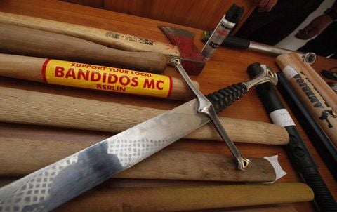 Waffen mit Bandidos-Emblem liegen nach einer Polizeiaktion in Flensburg auf einem Tisch. (ARCHIVFOTO: DDP)