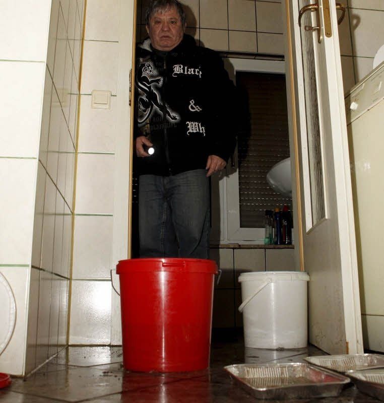 Eimerweise schöpft Christodulos Kefalas aus Hettstedt das Tauwasser aus seiner Küche.