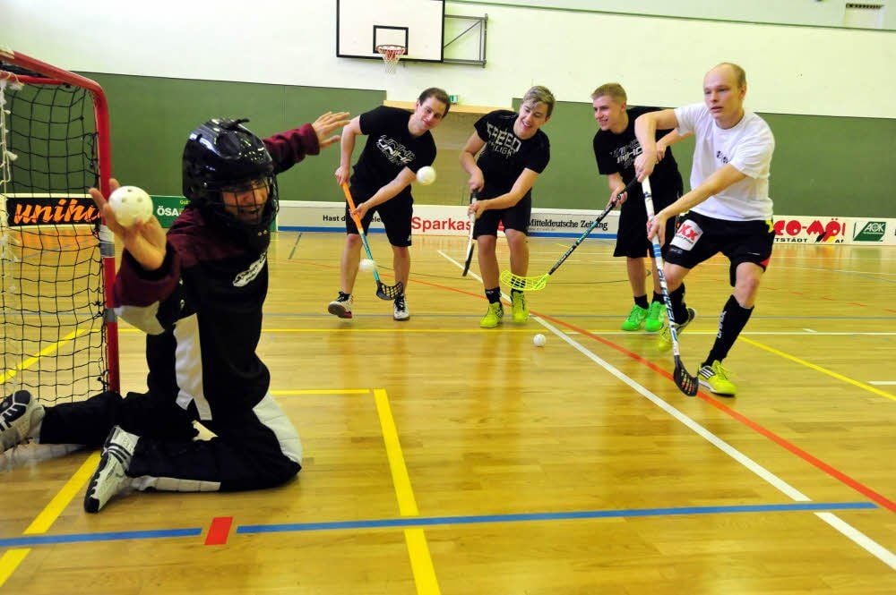 Die UHC-Bundesligaspieler Valentin Erben, Max Blanke, Matthias Siede und Sebastian Bernieck (von links) prüfen MZ-Mitarbeiter Thomé im Viererpack.