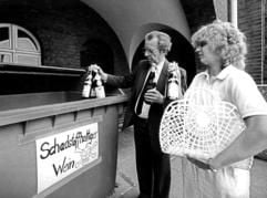 Zwei Bürger bringen im Juli 1985 in Krefeld Flaschen mit gepanschtem Wein zu einem eigens dafür aufgestellten Container. (Foto: dpa)