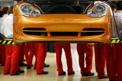 Mechatronik-Auszubildende stehen am Montag in der Porsche Leipzig GmbH an einem Auto. Im Zuge der Werkserweiterung des Leipziger Porsche- Werkes ist in den letzten zwei Jahren eine neü Lehrwerkstatt für 1,7 Millionen Euro entstanden, die am Montag offiziell eröffnet wurde. (FOTO: DDP)