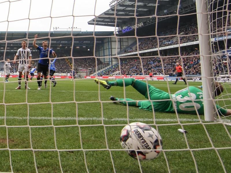 Arminia Bielefeld verkaufte Spieltag in der Schüco-Arena. Bielefelds Fabian Klos (hinten, 4.v.l) bejubelt den Treffer zum 1:0, während Torwart Robin Himmelmann (r) aus Hamburg geschlagen auf dem Rasen liegt. Foto: Friso Gentsch